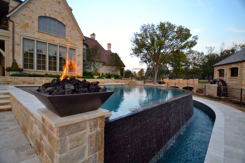 Geräumiger Klassischer Infinity-Pool hinter dem Haus in individueller Form mit Wasserspiel und Natursteinplatten in Dallas