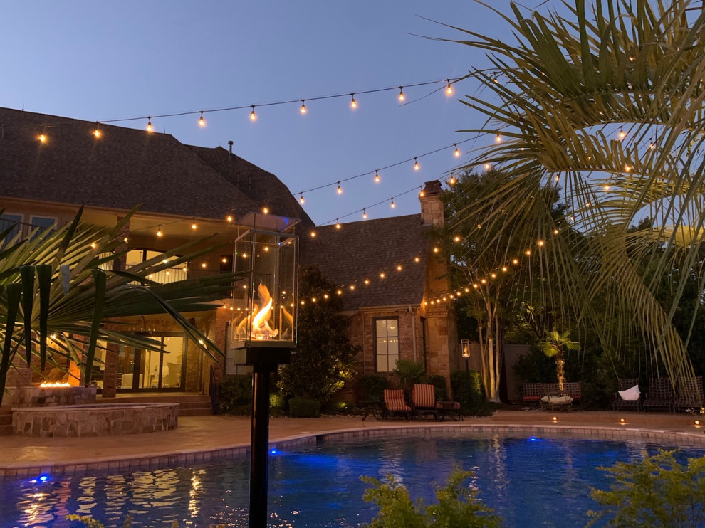 Foto de casa de la piscina y piscina tropical grande en patio trasero