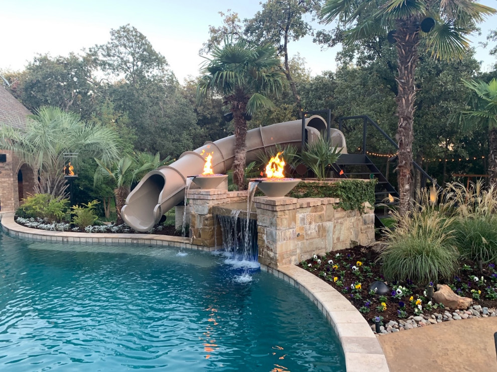 Diseño de piscina con tobogán exótica grande en patio trasero