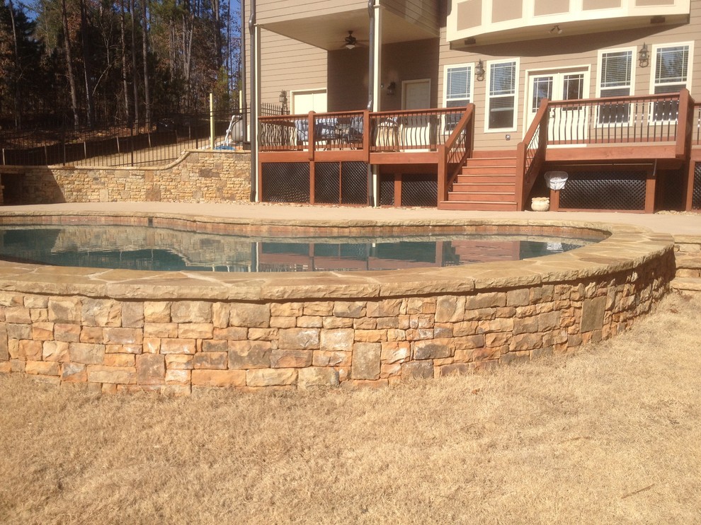 Modelo de piscina natural clásica de tamaño medio a medida en patio trasero con entablado