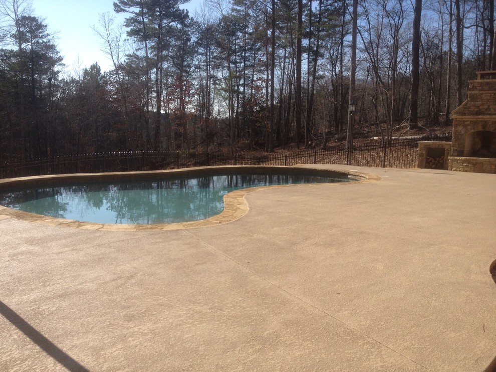Cette photo montre une piscine naturelle et arrière chic de taille moyenne et sur mesure avec une terrasse en bois.