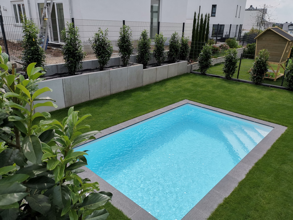 Diseño de piscina contemporánea pequeña rectangular en patio lateral con adoquines de piedra natural