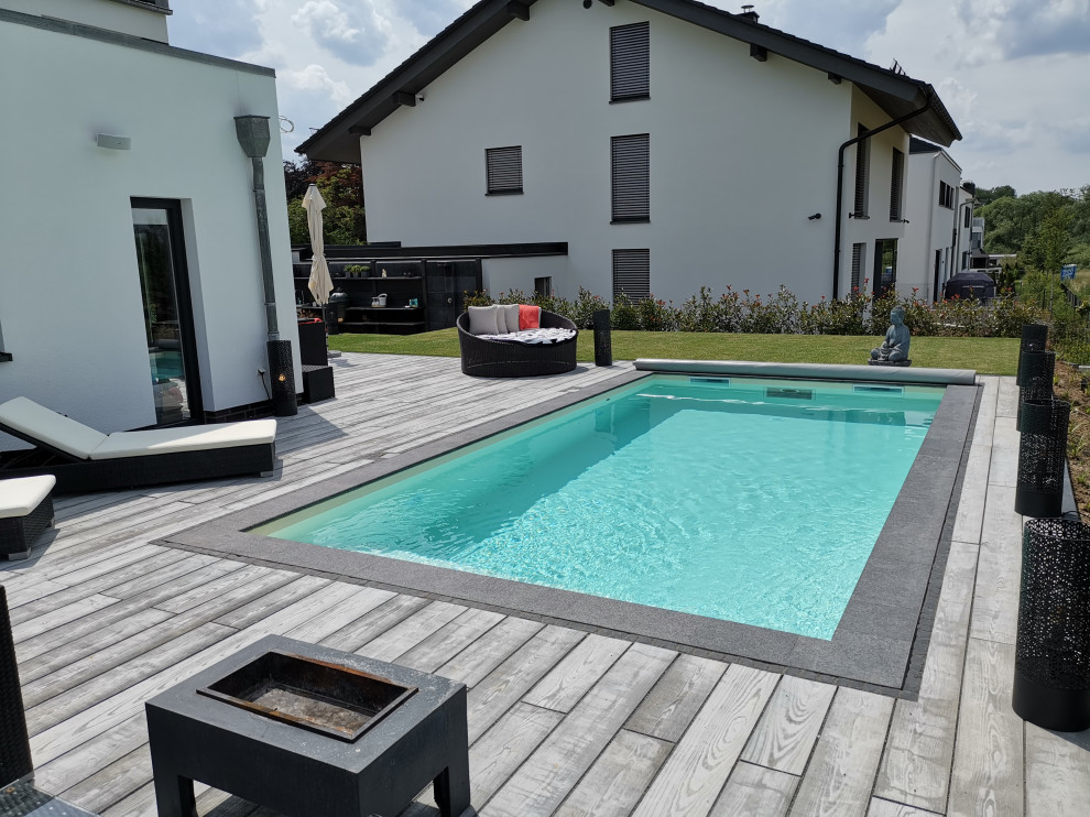 Diseño de piscina mediterránea de tamaño medio rectangular en patio lateral con adoquines de piedra natural
