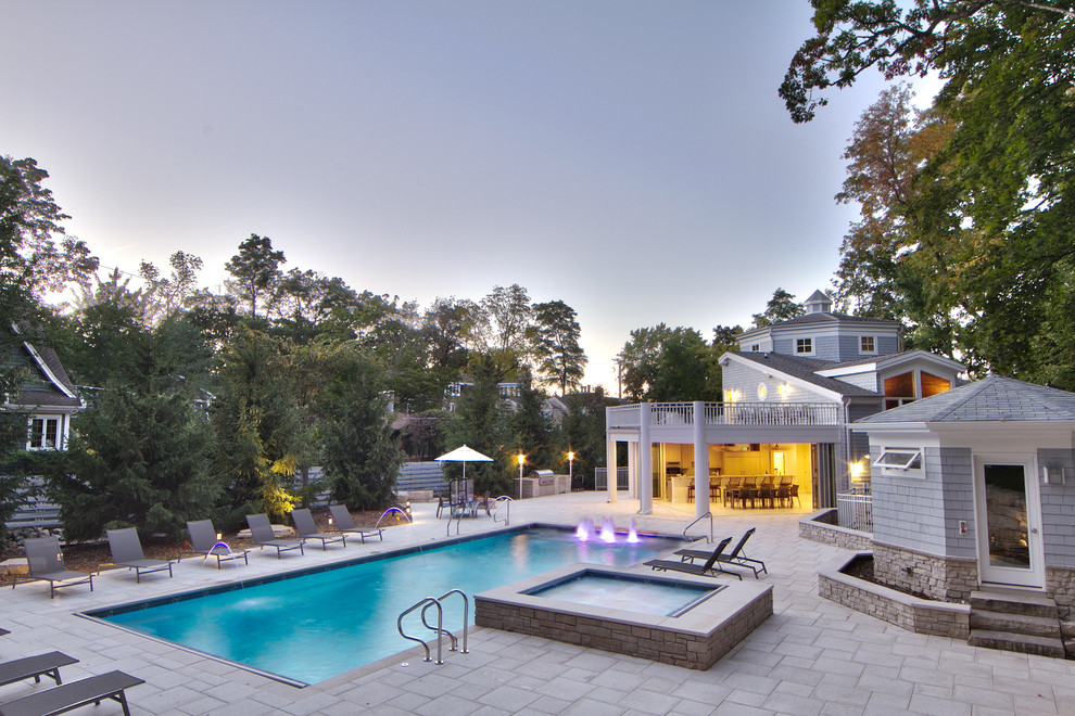 Diseño de piscinas y jacuzzis alargados clásicos de tamaño medio rectangulares en patio trasero con adoquines de piedra natural