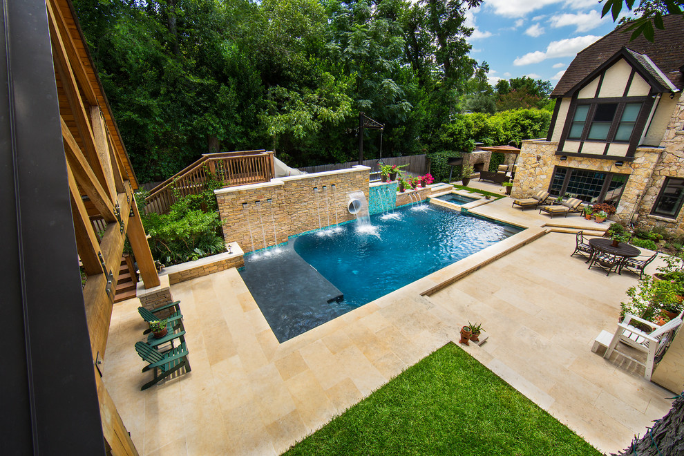 Photo of a large country side rectangular lengths swimming pool in Austin with a water slide and natural stone paving.
