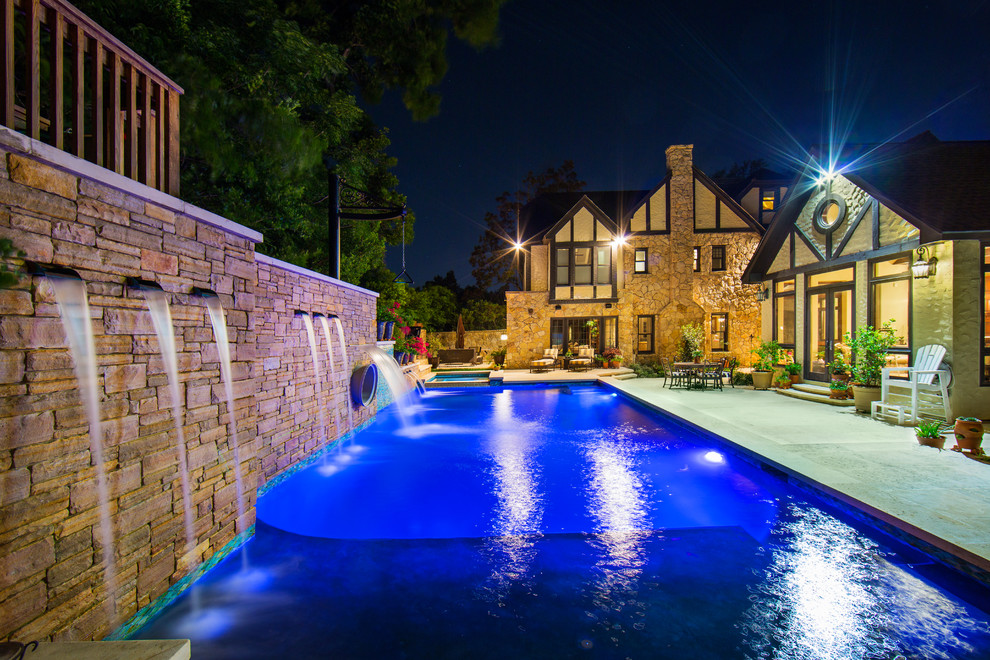 Imagen de piscina con tobogán alargada campestre grande rectangular en patio lateral con adoquines de piedra natural
