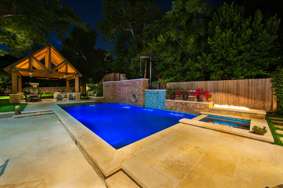 Ejemplo de piscina con tobogán alargada de estilo de casa de campo grande rectangular en patio lateral con adoquines de piedra natural