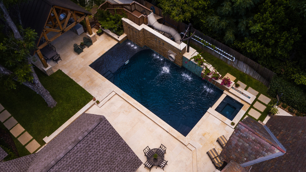 На фото: большой спортивный, прямоугольный бассейн на боковом дворе в стиле кантри с водной горкой и покрытием из каменной брусчатки