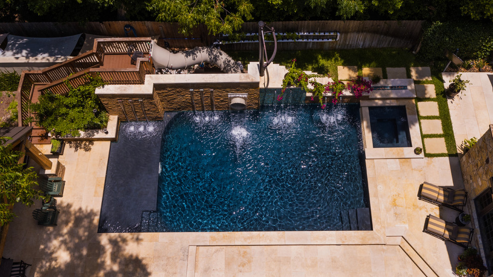 Foto de piscina con tobogán alargada de estilo de casa de campo grande rectangular en patio lateral con adoquines de piedra natural