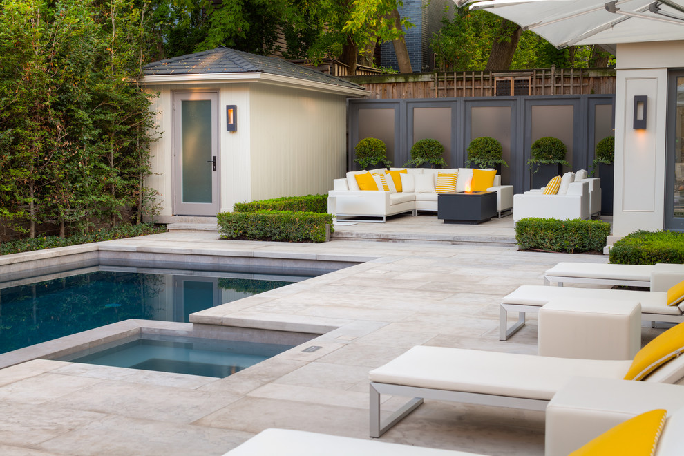 Ejemplo de piscina clásica de tamaño medio rectangular en patio trasero con adoquines de piedra natural