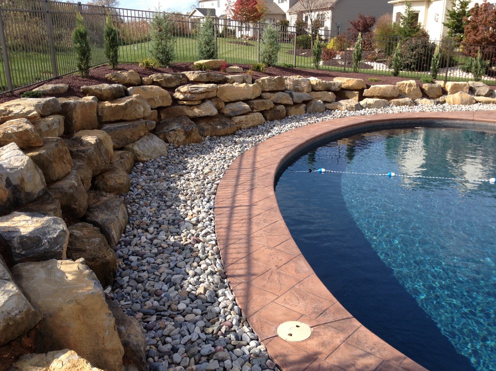 Foto de piscina natural clásica tipo riñón en patio trasero con suelo de hormigón estampado