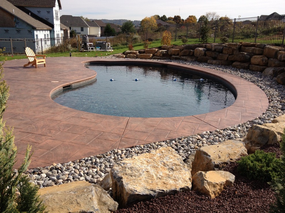 Idée de décoration pour une piscine naturelle et arrière tradition en forme de haricot avec du béton estampé.