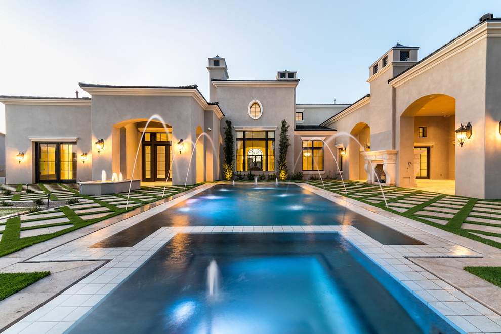 Modelo de piscina natural mediterránea extra grande rectangular en patio trasero con adoquines de piedra natural