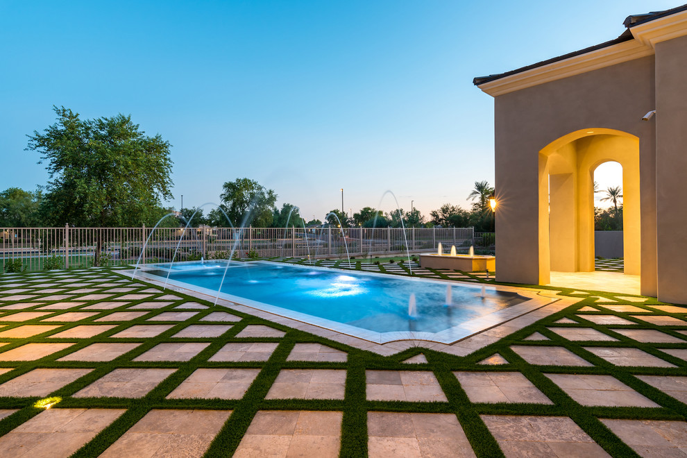 Ispirazione per un'ampia piscina monocorsia mediterranea rettangolare dietro casa con pavimentazioni in pietra naturale