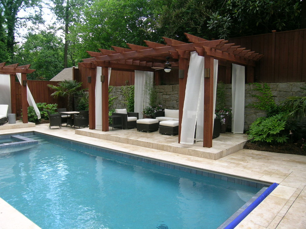Modelo de piscinas y jacuzzis naturales tradicionales de tamaño medio rectangulares en patio trasero con adoquines de piedra natural