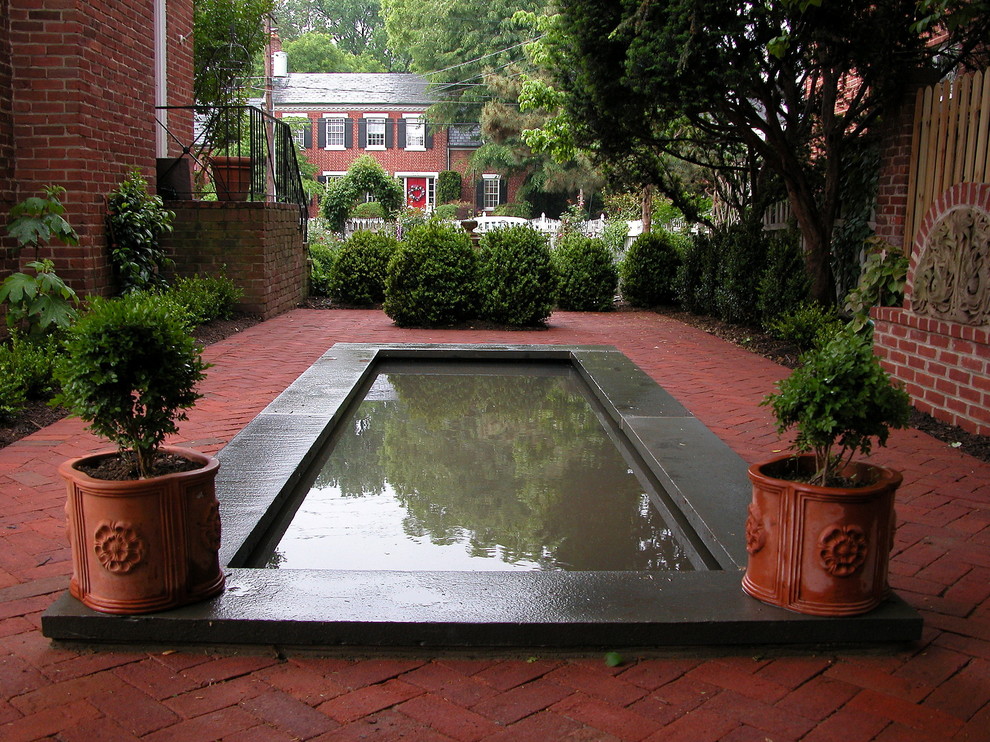 Modelo de piscina tradicional pequeña rectangular en patio lateral con adoquines de ladrillo