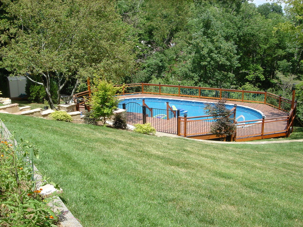 Foto di un'ampia piscina fuori terra design rettangolare dietro casa con una vasca idromassaggio e pedane