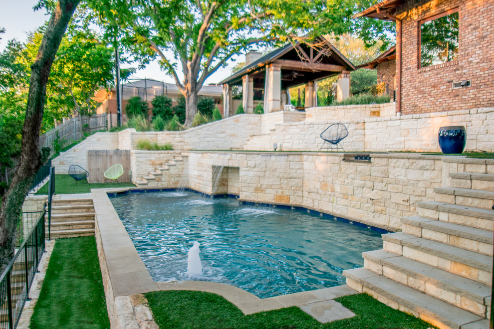 Modelo de piscina moderna de tamaño medio a medida en patio trasero con adoquines de piedra natural