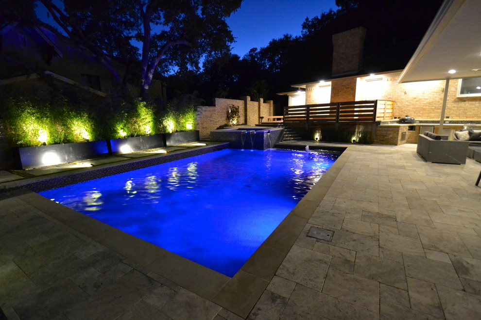 Foto de piscina con fuente clásica renovada rectangular en patio trasero con adoquines de piedra natural