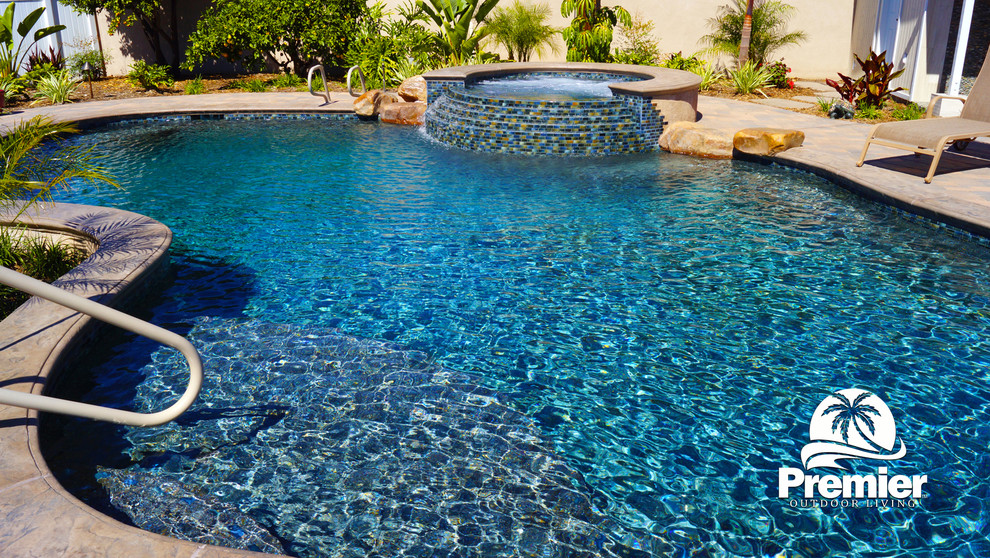 Foto di una grande piscina naturale tropicale personalizzata dietro casa con una dépendance a bordo piscina e pavimentazioni in cemento