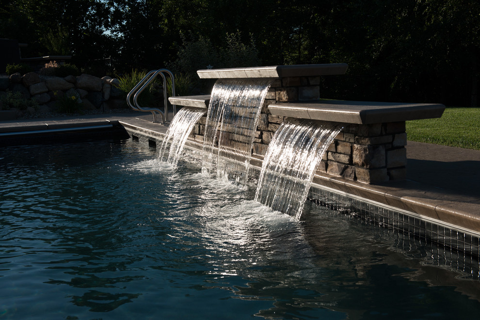 На фото: прямоугольный бассейн среднего размера на заднем дворе в современном стиле с фонтаном и покрытием из декоративного бетона с