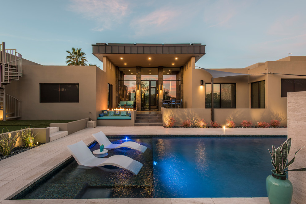Пример оригинального дизайна: большой прямоугольный бассейн на заднем дворе в современном стиле с покрытием из каменной брусчатки