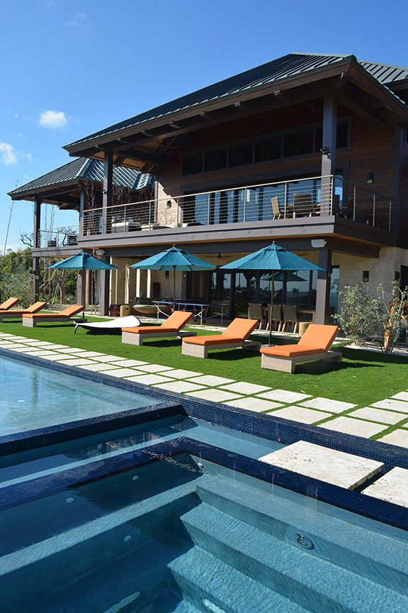Idee per una grande piscina monocorsia stile marino rettangolare dietro casa con una vasca idromassaggio e pavimentazioni in pietra naturale