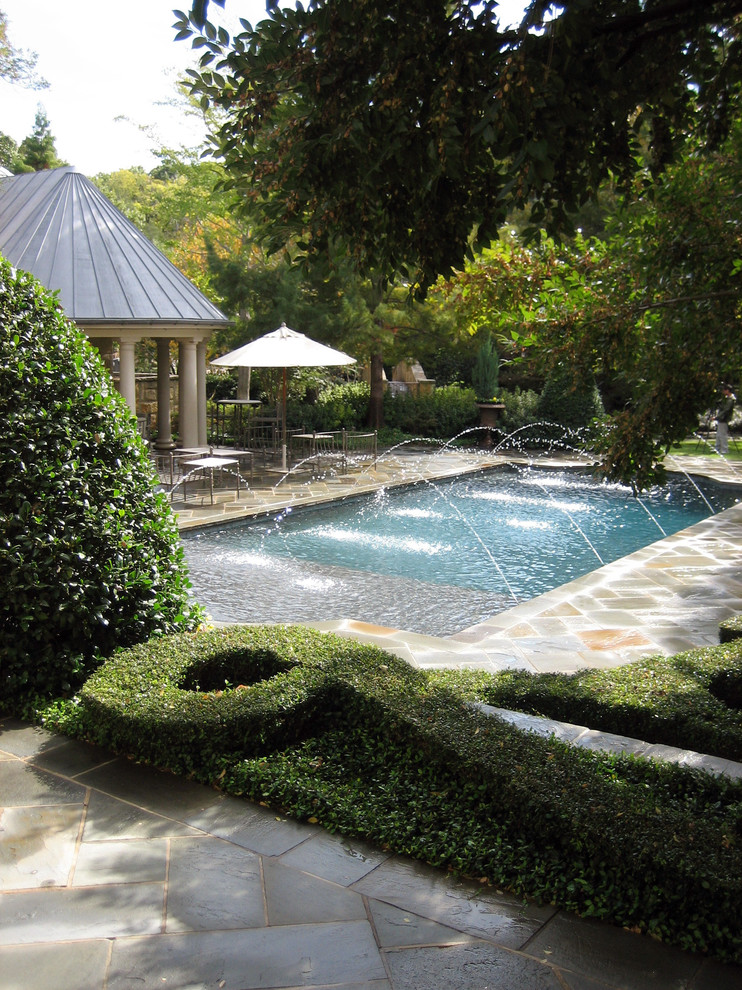 Exempel på en klassisk rektangulär pool, med naturstensplattor och en fontän