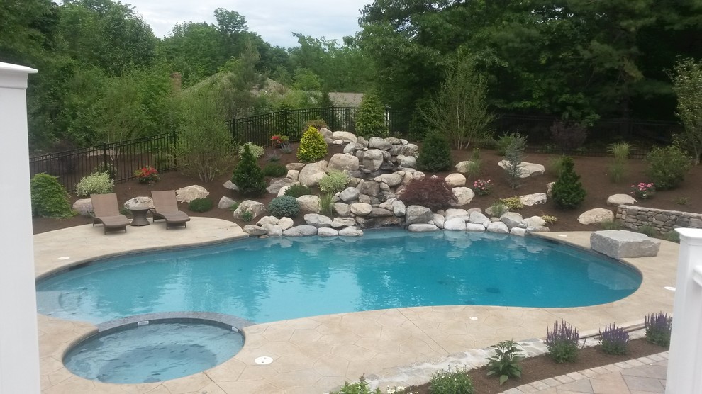 Foto de piscinas y jacuzzis naturales retro extra grandes redondeados en patio trasero con suelo de hormigón estampado