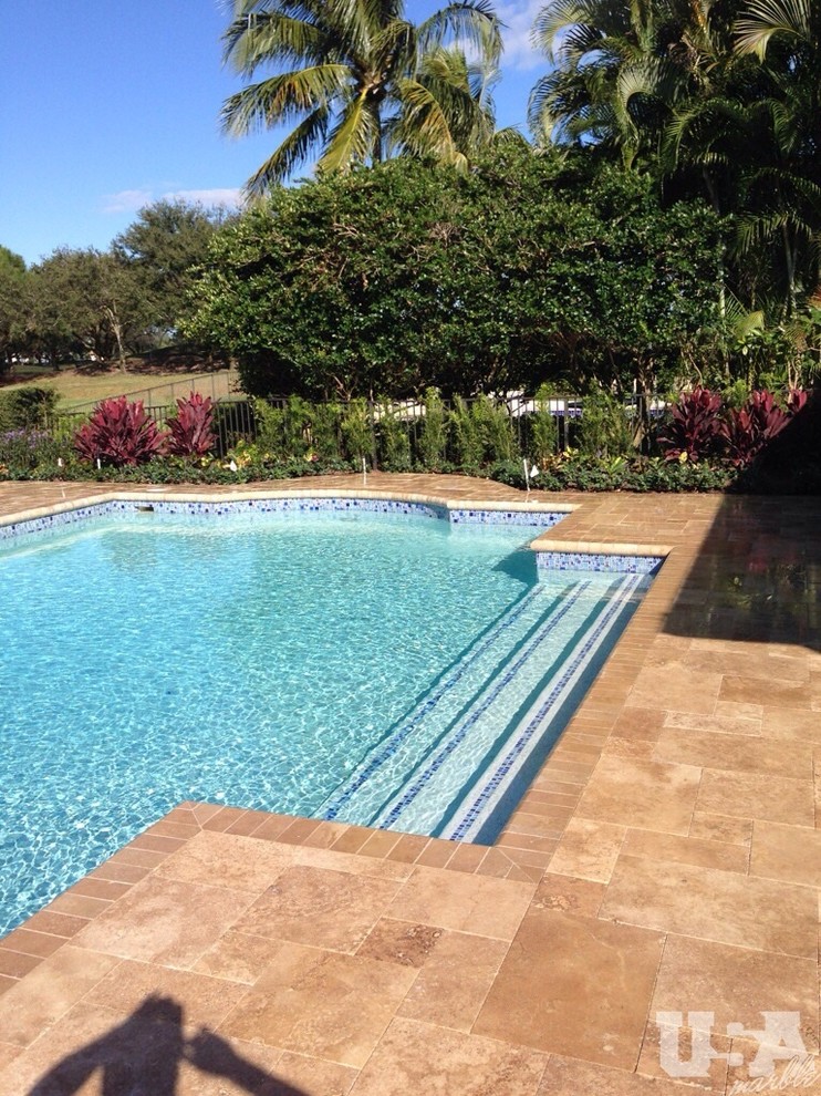 Foto de piscina elevada grande en patio trasero con adoquines de piedra natural