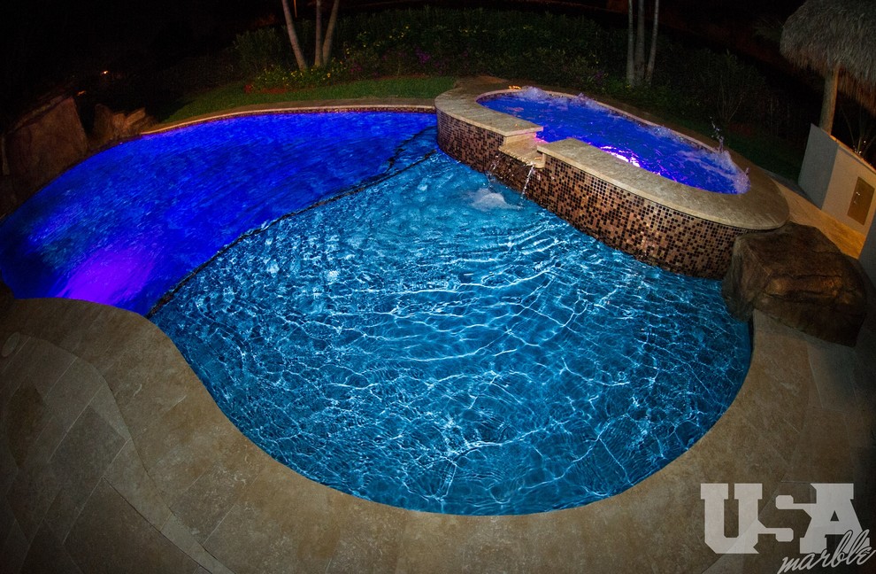 Идея дизайна: большой наземный бассейн в форме фасоли на заднем дворе в средиземноморском стиле с фонтаном и покрытием из каменной брусчатки