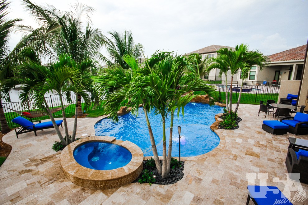 Exemple d'une grande piscine hors-sol et arrière sur mesure avec un point d'eau et des pavés en pierre naturelle.