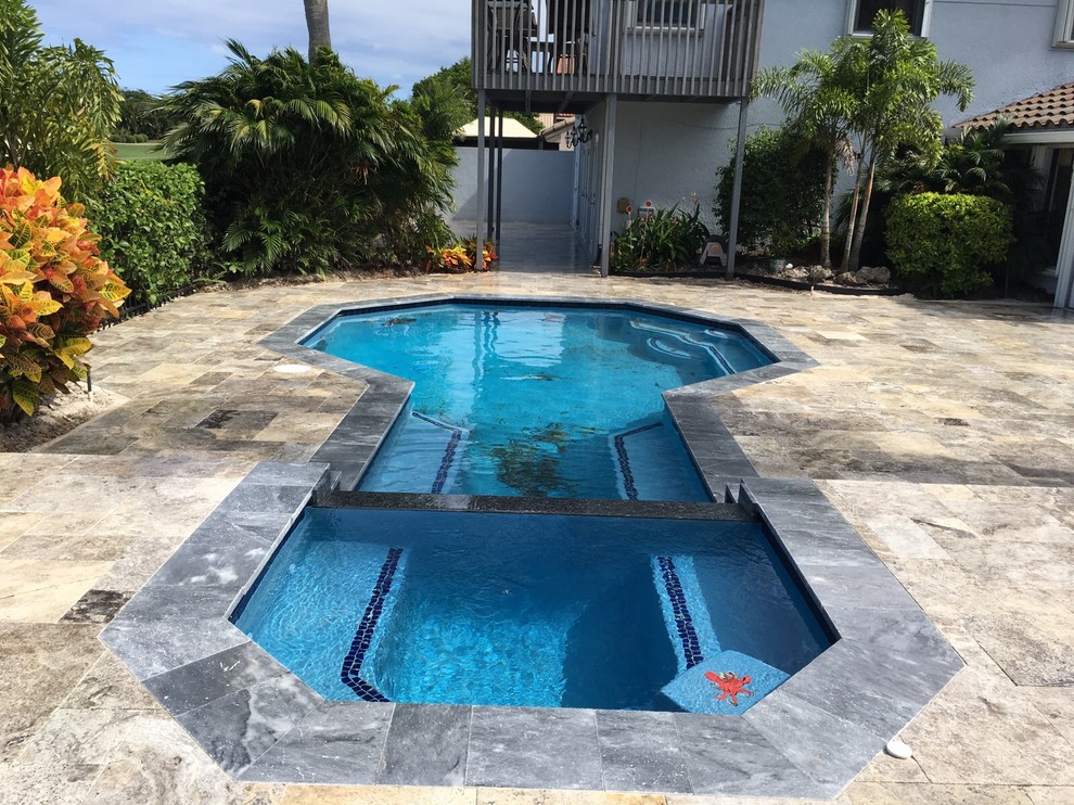 Esempio di una piscina design di medie dimensioni e dietro casa con pavimentazioni in pietra naturale