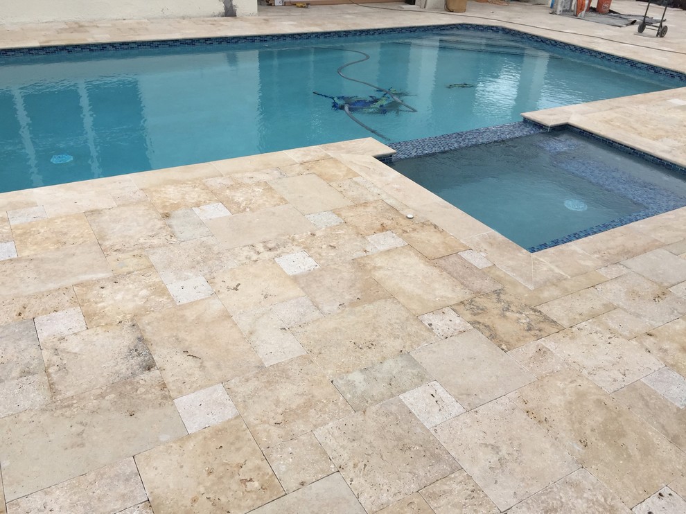 Example of a mountain style backyard stone and rectangular pool design in Miami