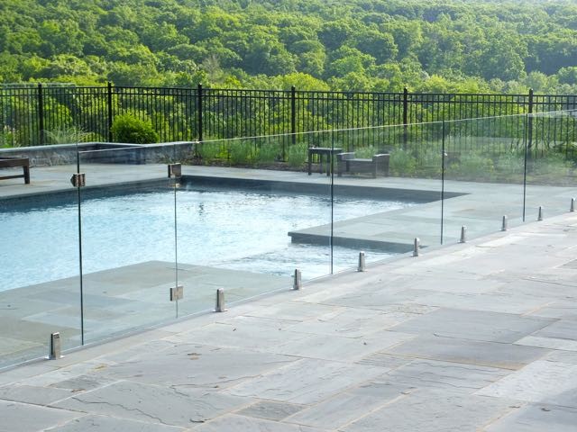 Exempel på en mellanstor modern rektangulär baddamm på baksidan av huset, med kakelplattor