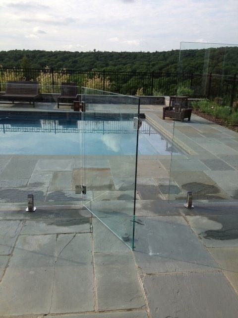 Imagen de piscina natural minimalista de tamaño medio rectangular en patio trasero con suelo de baldosas