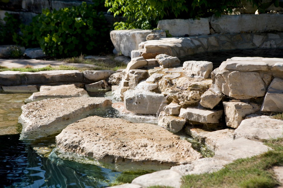 Réalisation d'une piscine arrière et naturelle champêtre de taille moyenne et sur mesure avec des pavés en pierre naturelle et un bain bouillonnant.