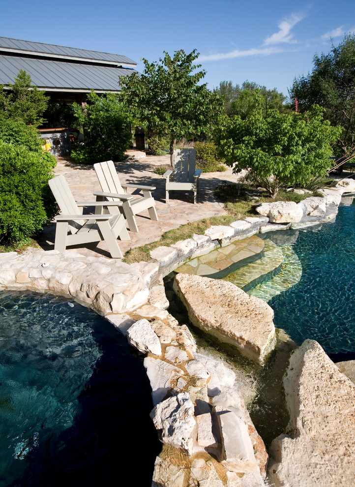 Foto di una piscina naturale country personalizzata dietro casa e di medie dimensioni con pavimentazioni in pietra naturale e una vasca idromassaggio