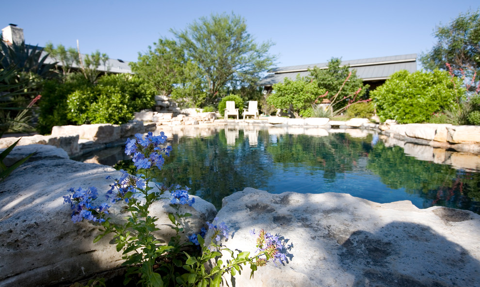 Ejemplo de piscinas y jacuzzis naturales de estilo de casa de campo de tamaño medio a medida en patio trasero con adoquines de piedra natural