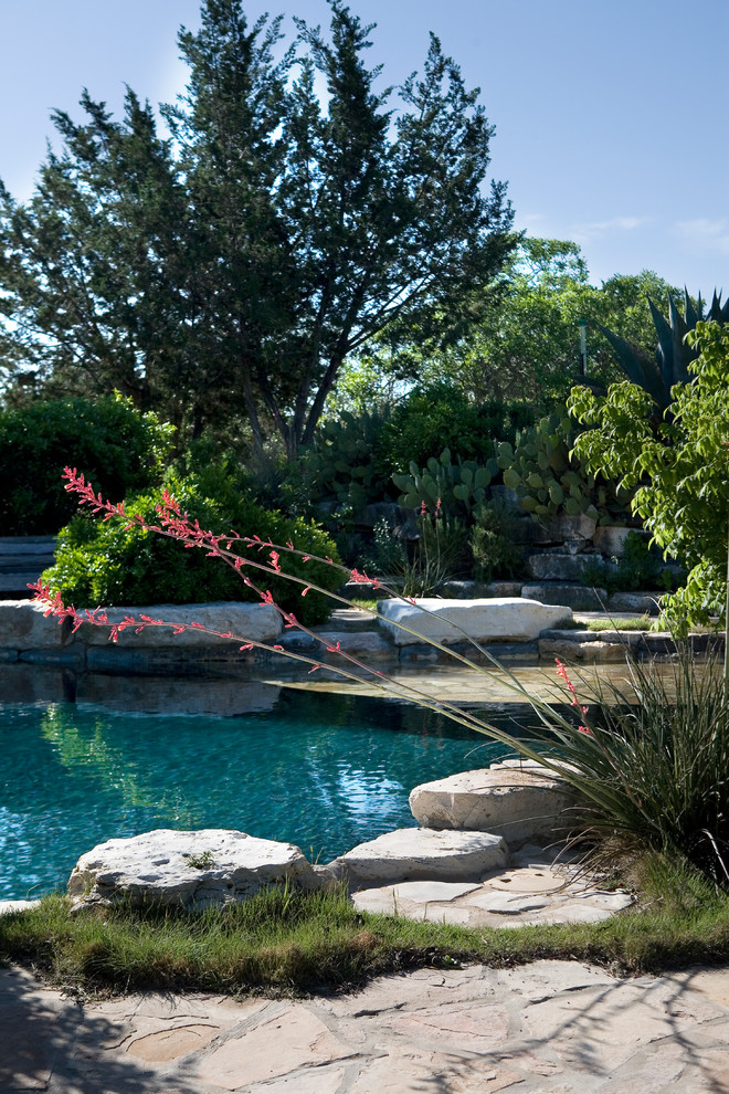Foto di una piscina naturale country personalizzata dietro casa e di medie dimensioni con pavimentazioni in pietra naturale e una vasca idromassaggio