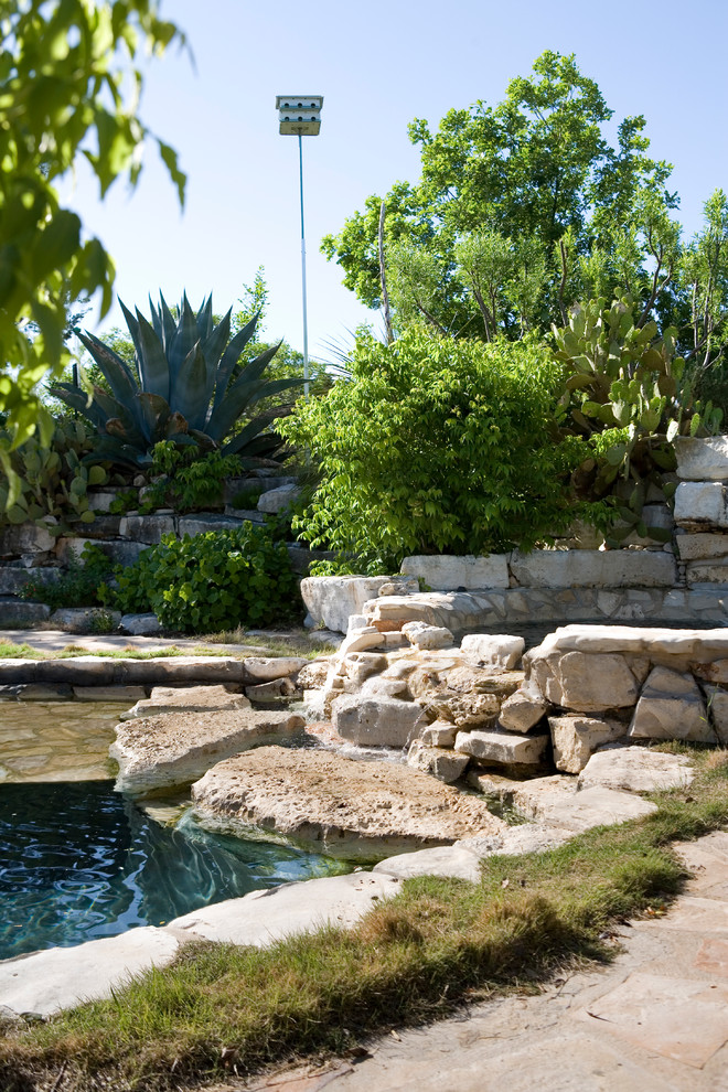 Idee per una piscina naturale country personalizzata dietro casa e di medie dimensioni con pavimentazioni in pietra naturale e una vasca idromassaggio