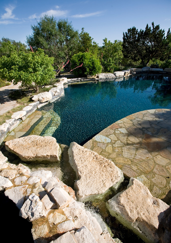Idée de décoration pour une piscine arrière et naturelle champêtre de taille moyenne et sur mesure avec des pavés en pierre naturelle et un bain bouillonnant.