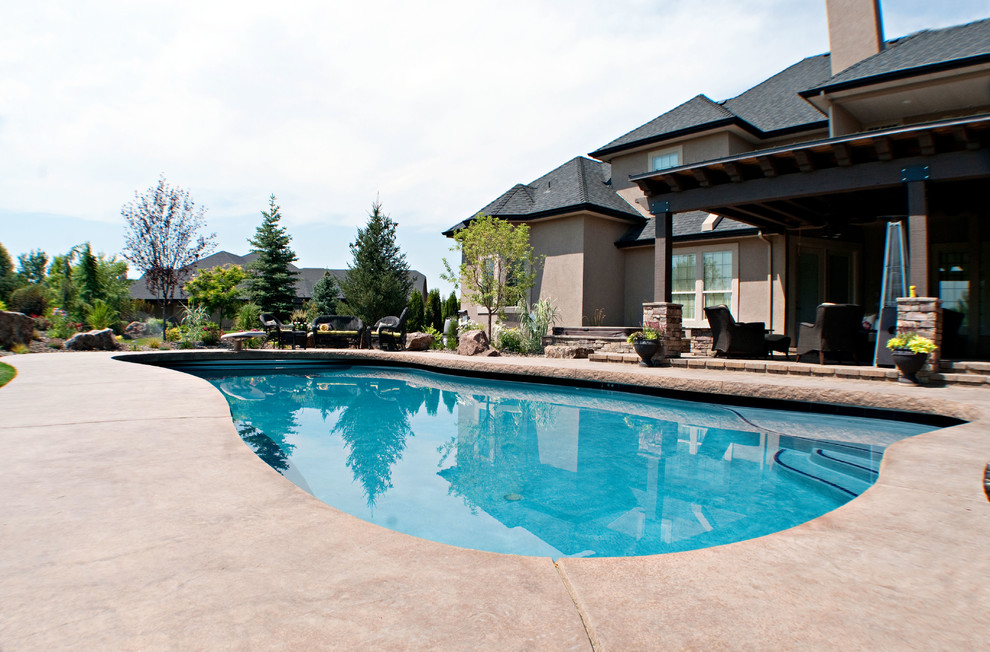 Inspiration for a mid-sized modern backyard concrete and custom-shaped pool remodel in Boise