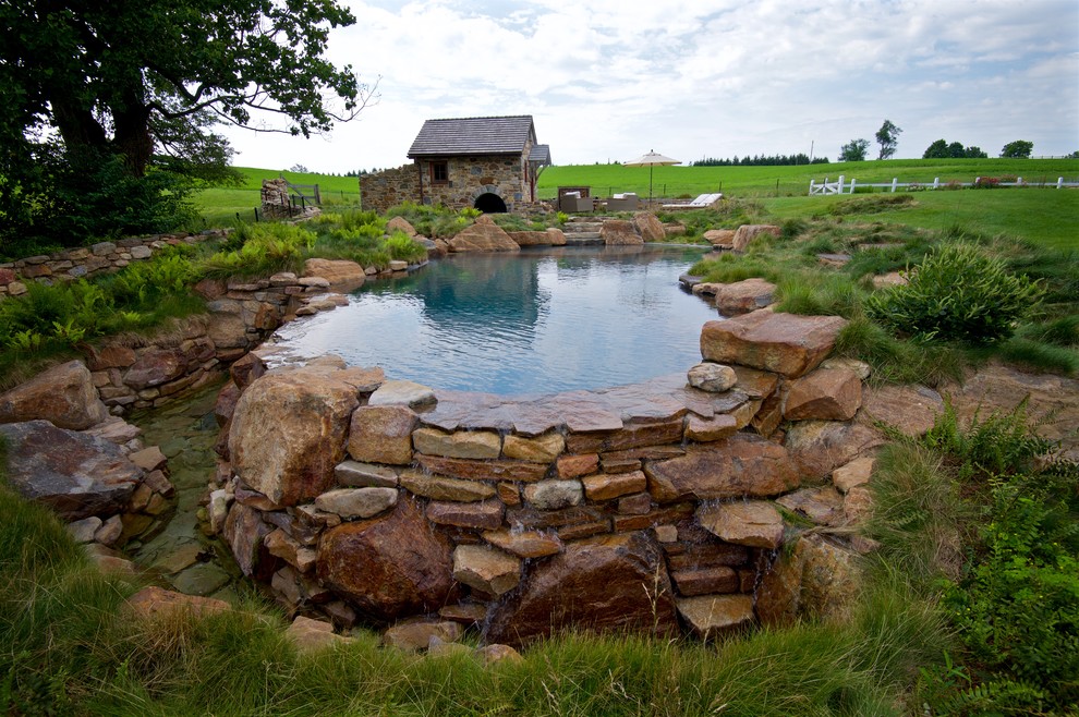 Hot tub - large rustic backyard custom-shaped infinity hot tub idea in Philadelphia