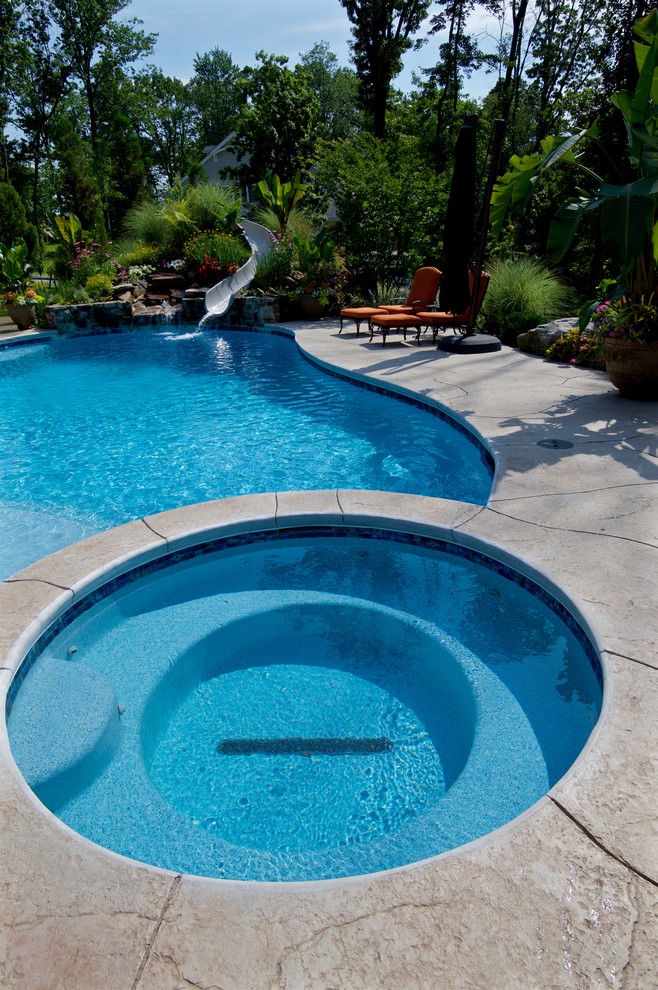 Свежая идея для дизайна: большой бассейн произвольной формы на заднем дворе в современном стиле с водной горкой и покрытием из декоративного бетона - отличное фото интерьера