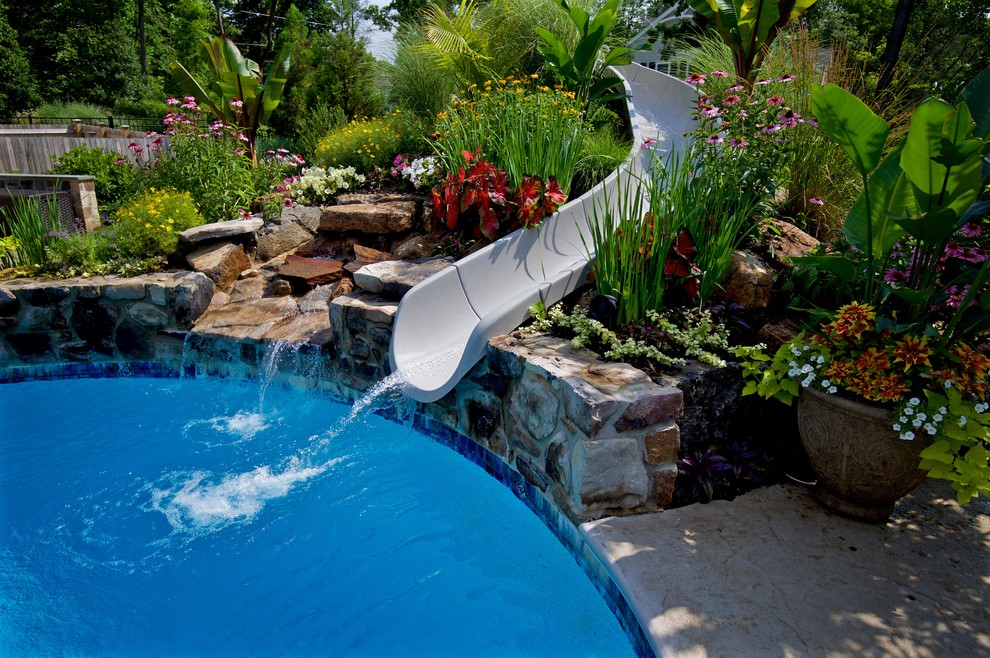 Idee per una grande piscina contemporanea personalizzata dietro casa con un acquascivolo e cemento stampato