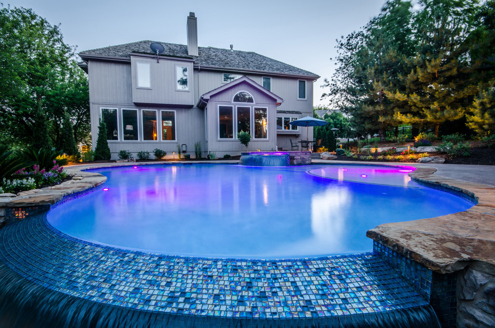 Idee per una grande piscina naturale classica personalizzata dietro casa con una vasca idromassaggio e cemento stampato