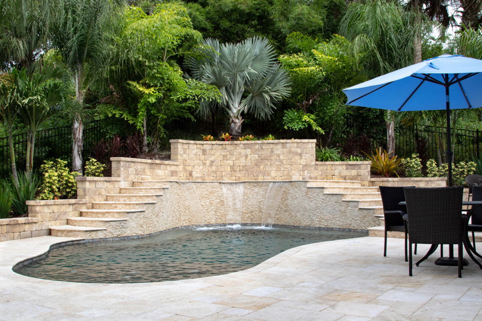Идея дизайна: ландшафтный бассейн произвольной формы на заднем дворе в морском стиле с покрытием из каменной брусчатки