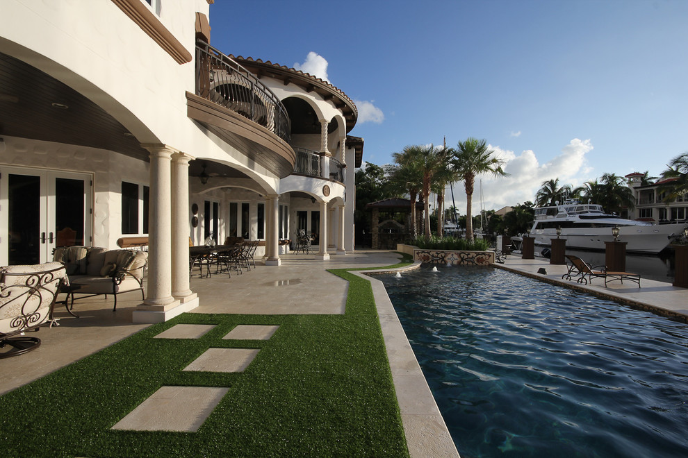 Mittelgroßer Moderner Pool hinter dem Haus in individueller Form mit Wasserspiel und Natursteinplatten in Miami