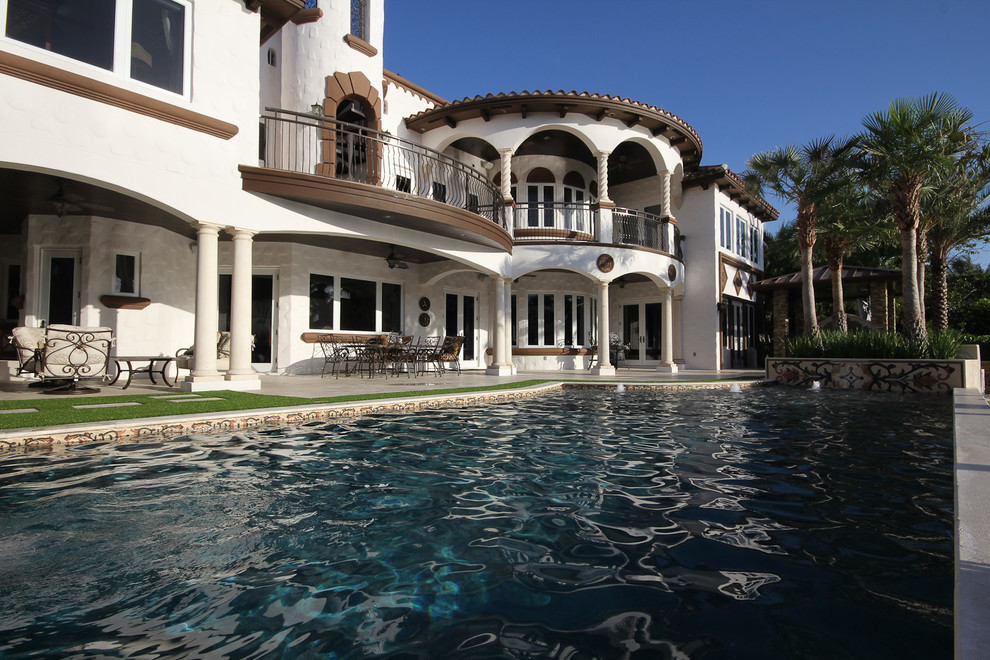 Foto di una piscina contemporanea personalizzata di medie dimensioni e dietro casa con fontane e pavimentazioni in pietra naturale